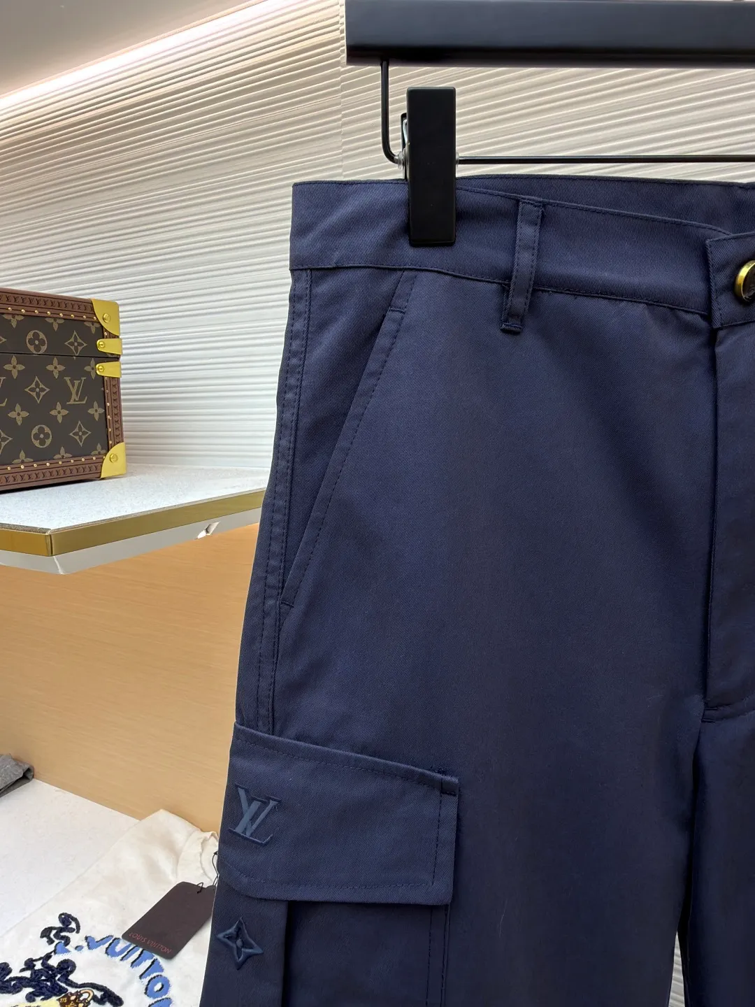 LOUIS VUITTON pocket embroidered work trousers ●Original version: Purchased and developed for 9999 ●Item number: 1681825-B50 ●Fabric: cotton twill fabric ●Technology: embroidery production ●Color: navy blue ●Version: fitted version ●Weight: about 520 grams ●Size: 44-46-48-50 ●Description: The high cotton content ensures the fabric's excellent breathability, durability and classic workwear texture, while the twill weave gives it unique wear resistance and stiffness. The special fabric technology solves the pain points of tight and stiff traditional overalls; it provides greater freedom when moving, significantly improves wearing comfort and flexibility, and achieves a balance between function and comfort. The application of three-dimensional core-spinning embroidery technology in the pocket position is achieved by adding additional cotton thread or foam as the core material to the pattern filling layer, and then using embroidery thread to fully cover the embroidery. The logo pattern is significantly protruded from the surface of the fabric, forming a full three-dimensional effect. This process not only enhances the visual impact and tactile level, but also improves the wear resistance of the pocket area through the buffering effect of the core material, ensuring that the pattern can still remain crisp and not deformed in complex daily use, ensuring that the pattern is clear and durable, and injecting a sense of sophistication into the rugged workwear style. Diversified pocket system combines workwear functionality with sophistication. The flap cargo pockets on both sides are a signature element, and their flap design prevents items from falling and enhances the visual three-dimensionality. Italian style pockets provide simple side storage. The overall wiring is straight and delicate, the fabric is comfortable and soft, and the color is consistent without color difference. It can be matched with the same style to create a fashionable look and control various occasions. Customized accessories, complete with three standards, same style for men and women!